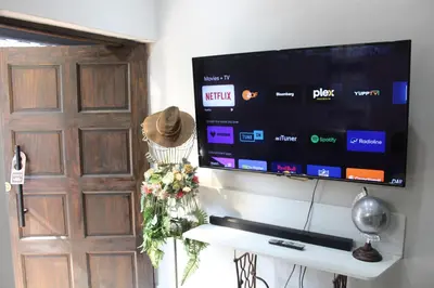 a flat screen tv on a wall next to a door at Rose Stable Cottage in Pretoria