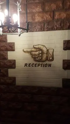 a mural of a hand holding a sign on a brick wall at Premier Hotel and Spa Cullinan in Cullinan