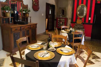 a dining room with two tables and a mirror at Premier Hotel and Spa Cullinan in Cullinan