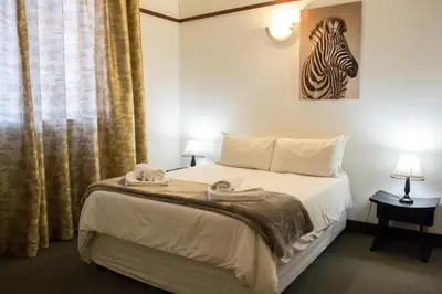 a bedroom with a bed with a zebra picture on the wall at Premier Hotel and Spa Cullinan in Cullinan