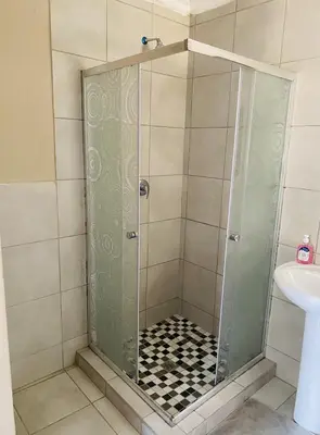 a shower with a glass door in a bathroom at Lesari Stay in Centurion