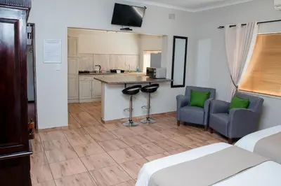 a hotel room with two beds and a kitchen at 85 Ehmke Guesthouse in Nelspruit