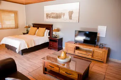 a bedroom with a bed and a flat screen tv at 85 Ehmke Guesthouse in Nelspruit