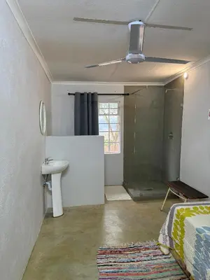 a bathroom with a sink and a ceiling fan at Kanaan Guest Farm in Hazyview