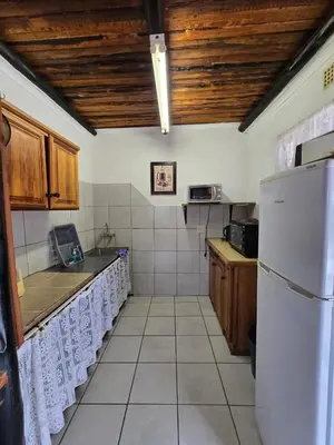 a kitchen with wooden ceilings and a white refrigerator at Kanaan Guest Farm in Hazyview