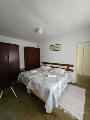 a bedroom with two beds and a chair at Kanaan Guest Farm in Hazyview