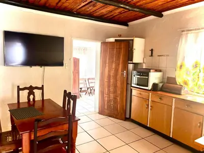a kitchen with a table and a television and a kitchen with a table sidx sidx at Kanaan Guest Farm in Hazyview