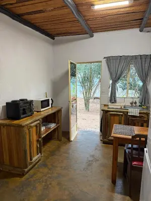 a room with a kitchen with a microwave and a table at Kanaan Guest Farm in Hazyview