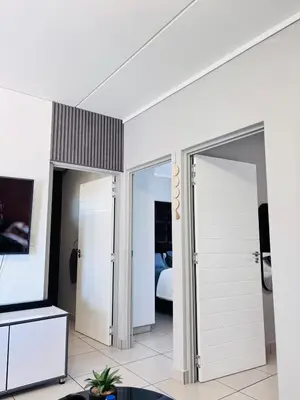 a room with two doors leading to a bedroom at Grey Heaven Retreat in Boschrand