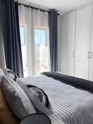 a bedroom with a bed with pillows and a window at Grey Heaven Retreat in Boschrand