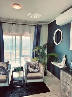 a living room with two chairs and a large window at Grey Heaven Retreat in Boschrand