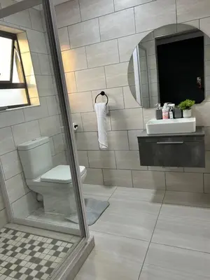 a bathroom with a toilet and a sink and a mirror at Okuhle Guesthouse Steelpoort in Steelpoort