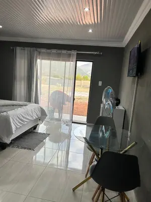 a bedroom with a bed and a glass table at Okuhle Guesthouse Steelpoort in Steelpoort