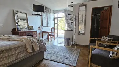 a bedroom with a bed and a living room at Upstairs R-3 Self Catering Unit in White River
