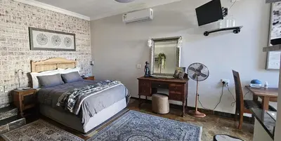 a bedroom with a bed and a mirror and a desk at Upstairs R-3 Self Catering Unit in White River