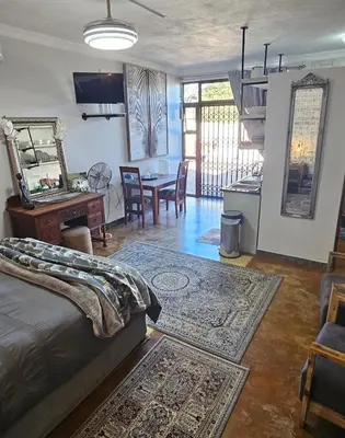 a living room with a bed and a dining room at Upstairs R-3 Self Catering Unit in White River