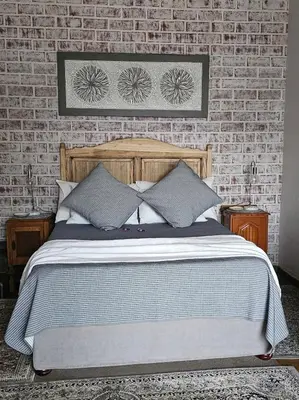 a bedroom with a bed and a brick wall at Upstairs R-3 Self Catering Unit in White River