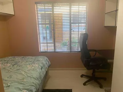 a desk and a chair in a room with a window at Imani's Retreat in Midrand