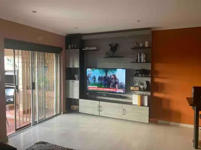 a living room with a flat screen tv on a entertainment center at Imani's Retreat in Midrand
