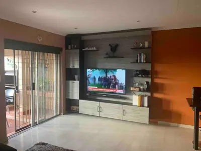 a living room with a flat screen tv on a entertainment center at Imani's Retreat in Midrand