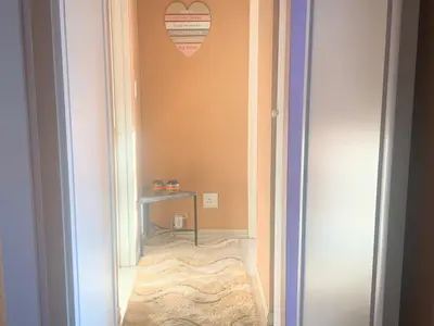 a hallway with a table and a heart on the wall at Imani's Retreat in Midrand