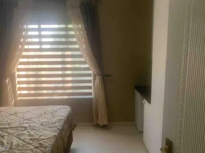 a bedroom with a bed and a window with curtains at Imani's Retreat in Midrand