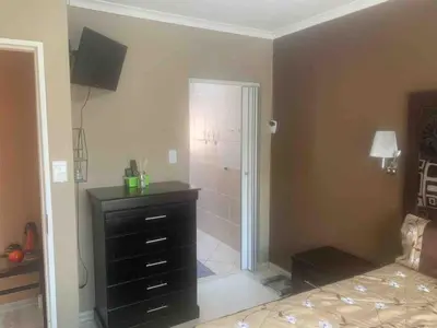a bathroom with a black dresser and a shower at Imani's Retreat in Midrand