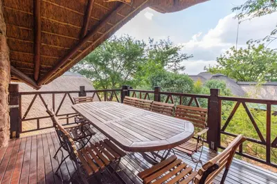 a wooden table and chairs on a deck at Zebula 4-bedroom, 12 sleeper - 63 in Warmbaths