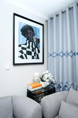 a living room with a couch and a picture on the wall at Waterfall luxe apartment in Kyalami