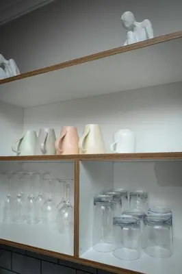 a shelf filled with glasses and vases at Waterfall luxe apartment in Kyalami