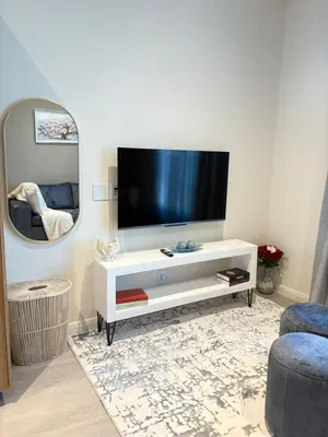 a living room with a television on a white entertainment center at Studio Sol at Trilogy in Pretoria