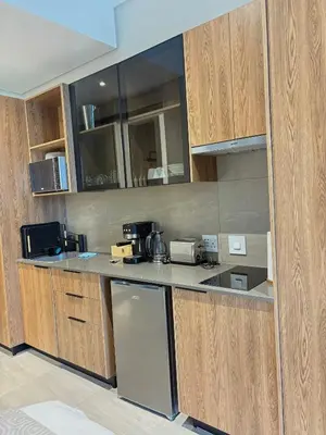 a kitchen with wooden cabinets and a counter top at Studio Sol at Trilogy in Pretoria