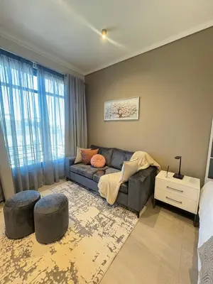 a living room with a couch and a bed at Studio Sol at Trilogy in Pretoria