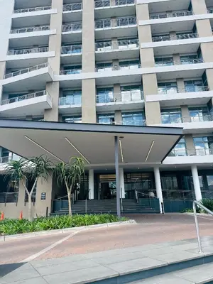 an apartment building with a parking lot in front of it at Studio Sol at Trilogy in Pretoria