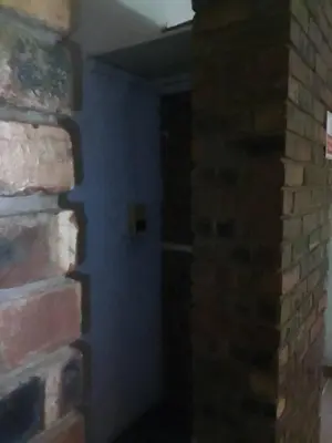 a room with a blue wall and a brick wall at Mountain Guesthouse in Pretoria