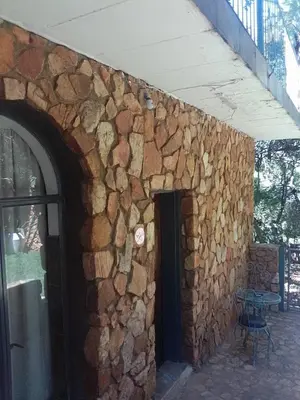 a building with a stone wall with a door at Mountain Guesthouse in Pretoria