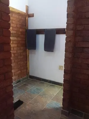a bathroom with two towels hanging on a wall at Mountain Guesthouse in Pretoria
