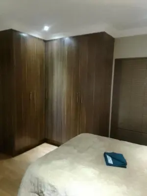 a bedroom with a large bed with wooden cabinets at New Beautiful Apartment in Middelburg