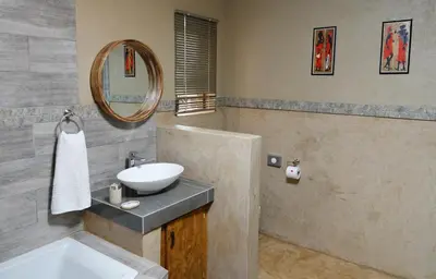 a bathroom with a sink and a mirror at Tau @ Kruger in Marloth Park