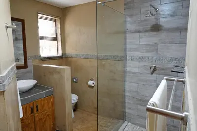 a bathroom with a shower with a toilet and a sink at Tau @ Kruger in Marloth Park