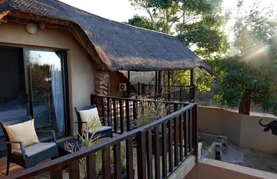 a porch of a house with a thatch roof at Tau @ Kruger in Marloth Park