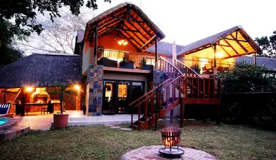 a house with a staircase in the yard at Tau @ Kruger in Marloth Park