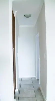a hallway with white walls and a tile floor at Modern 2BR Retreat at The Blyde in Pretoria