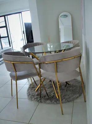 a dining room with a glass table and chairs at Modern 2BR Retreat at The Blyde in Pretoria