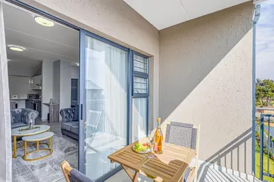 a balcony with a table and chairs and a room at 225 The Woods, Kyalami in Midrand