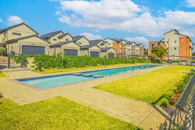 a swimming pool in a yard with houses at 225 The Woods, Kyalami in Midrand
