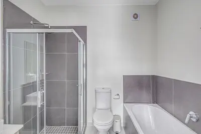 a white bathroom with a toilet and a shower at 225 The Woods, Kyalami in Midrand