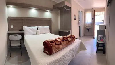a bedroom with a bed with a wooden headboard at Private 4 Double Room Guest Wing, Comfortable, Secure Parking, Wi-Fi, Ensuite Bath in Ermelo
