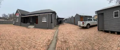 a brick parking lot with houses and a truck at Private 4 Double Room Guest Wing, Comfortable, Secure Parking, Wi-Fi, Ensuite Bath in Ermelo