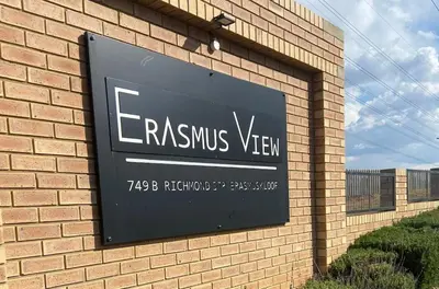 a sign on the side of a brick building at Warm, Homely Apartment - 5min Away Menlyn Main in Pretoria